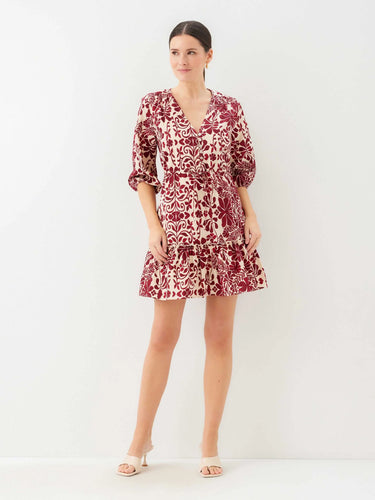 Woman wearing a red and white patterned dress on a white background