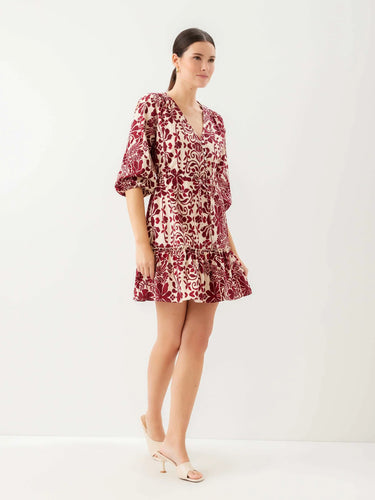 Woman wearing a patterned dress on a white background