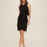 Woman wearing a black dress against a beige background
