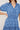 Blue patterned dress worn by a person on a plain background