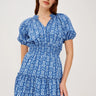 Woman wearing a blue patterned dress on a white background