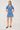 Woman wearing a blue patterned dress on a white background