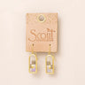 A pair of gold-tone drop earrings with stacked rectangular mosaic inlays, displayed on a tan card labeled 'Scout Curated Wears' against a light beige background.