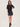 A woman wearing a black tee, faux leather skirt in black with brown loafers on a white background.