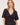 A woman wearing a v neck poplin top with ruching at the center on a white background