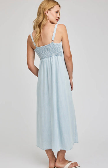Woman wearing a light blue dress with lace details on a white background