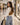 a woman in a mall carrying a leather half moon bag in Camel.