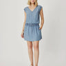 A women wearing a light blue cotton denim dress with an adjustable waistband