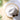 White sun hat and sunglasses on a white towel with palm leaves