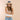 Woman wearing a straw hat with a blue band on a beige background