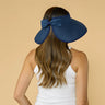 Woman wearing a blue visor on a beige background