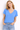 Woman wearing a blue V-neck t-shirt and jeans against a white background