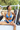 Woman in a blue bikini sitting in an open vehicle with greenery in the background