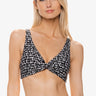 Woman wearing a black and white patterned bikini top on a white background