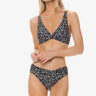 Woman wearing a black and white patterned bikini on a white background