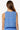 Woman wearing a blue sleeveless top with a white pattern on a white background