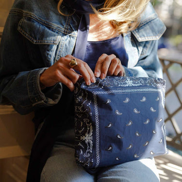 A woman holding the medium navy bandana zippered pouch 