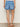 Person wearing blue denim shorts on a plain background