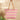 Woven tote bag with pink and green pattern on a beige background