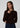 a woman wearing a dark brown cardigan and dark blue jeans on a white background