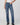 Person wearing blue jeans and black shoes on a white background