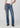 Person wearing blue jeans and black shoes on a white background