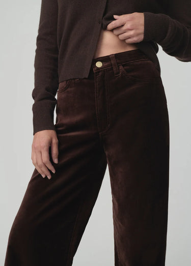 Chocolate brown button-front cardigan styled with matching wide-leg velvet pants and pointed-toe shoes on a model.