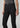 Black slim bootcut jeans styled with a metallic silver top and pointed-toe black heels on a model.
