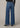 Blue jeans worn by a person on a beige background