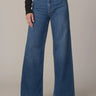 Person wearing blue wide-leg jeans on a neutral background