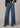 Person wearing blue wide-leg jeans on a neutral background