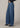 Person wearing blue wide-leg jeans on a plain background
