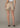 Beige shorts worn by a person on a plain background