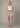 A woman wearing a white tank and tan relaxed fit 6 in inseam shorts