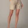 Beige denim shorts worn by a person on a neutral background