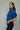 Woman wearing a blue denim jacket against a plain background