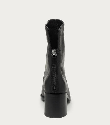 The image shows the back of a black leather heeled ankle boot with a zipper detail on a white bckground.