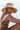 a woman wearing a straw sun hat on the beach