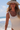 A woman wearing a floppy green hat on the beach