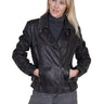 Woman wearing a black leather moto jacket with an asymmetrical zipper, paired with a charcoal turtleneck and grey jeans.