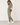 A woman modeling an olive green lounge set consisting of a crewneck sweatshirt and matching joggers, both decorated with white star patches. The sweatshirt features striped details on the sleeves in cream, gray, and black.