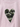 A close-up of a light pink heathered t-shirt featuring a central heart-shaped patch with a green, black, and gray camouflage pattern and a white serrated border.