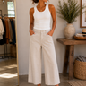 A woman wearing beige cropped wide leg pants in a store