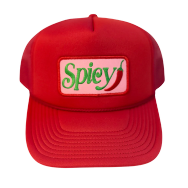A red trucker-style cap with a rectangular embroidered patch on the front that reads 'Spicy' in green script with a red chili pepper and a light pink background.