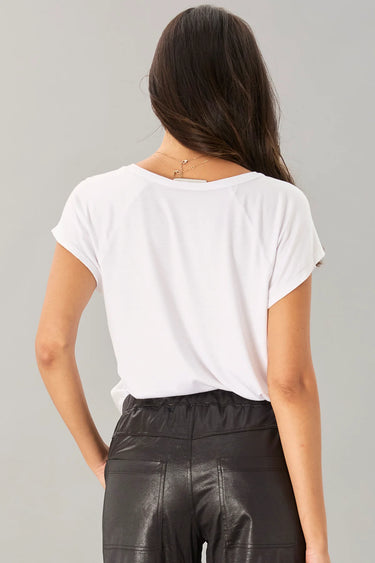 Person wearing a white t-shirt and black pants on a gray background