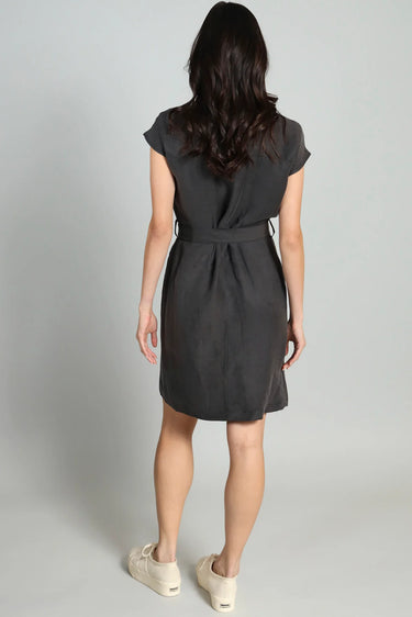 Woman wearing a dark gray dress against a plain background