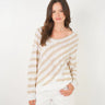 A woman wearing a knit beige and white striped sweater
