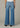 Person wearing blue jeans on a neutral background
