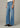 Person wearing blue wide-leg jeans on a neutral background