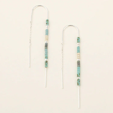 Pair of beaded earrings on a beige background